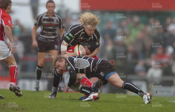 24.04.07 - Llanelli Scarlets v Ospreys - Magners League - Llanelli's Barry Davies is tackled by Duncan Jones (top) and Justin Marshall 