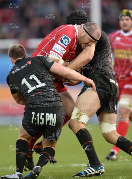 261213 - Scarlets v Ospreys - RaboDirect PRO12 -Phil John of Scarlets is tackled by Jeff Hassler and Ryan Jones of Ospreys