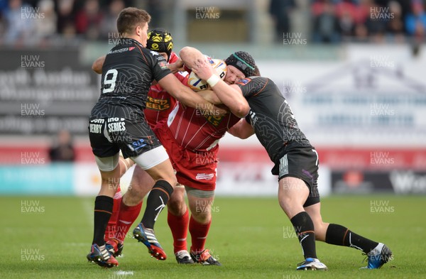 261213 - Scarlets v Ospreys - RaboDirect PRO12 -Samson Lee of Scarlets is tackled by Rhys Webb and Jeff Hassler of Ospreys