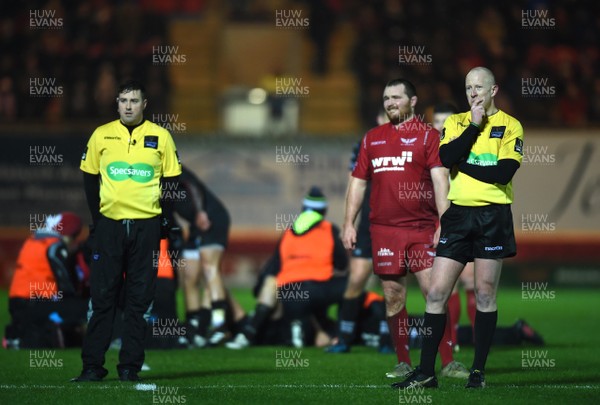 261217 - Scarlets v Ospreys - Guinness PRO14 - Assistant Referee Ben Whitehouse, Ken Owens of Scarlets and Referee Ian Davies watch the big screen while Steff Evans of Scarlets and Ben John of Ospreys are treated
