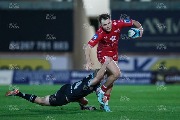 261223 - Scarlets v Ospreys - United Rugby Championship - Ioan Lloyd of Scarlets is tackled by Mat Protheroe of Ospreys