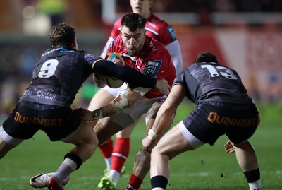 261225 - Scarlets v Ospreys - United Rugby Championship - Johnny Williams of Scarlets is tackled by Kieran Hardy of Ospreys 