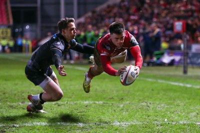 261225 - Scarlets v Ospreys - United Rugby Championship - Joe Roberts of Scarlets scores a try despite the tackle of Kieran Hardy of Ospreys