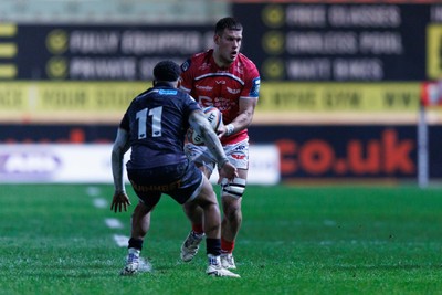 261225 - Scarlets v Ospreys - United Rugby Championship - Jarrod Taylor of Scarlets takes on Keelan Giles of Ospreys