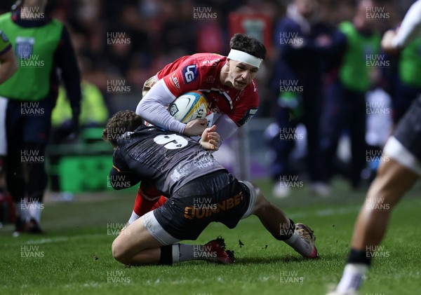 261225 - Scarlets v Ospreys - United Rugby Championship - Tom Rogers of Scarlets is tackled by Kieran Hardy of Ospreys 