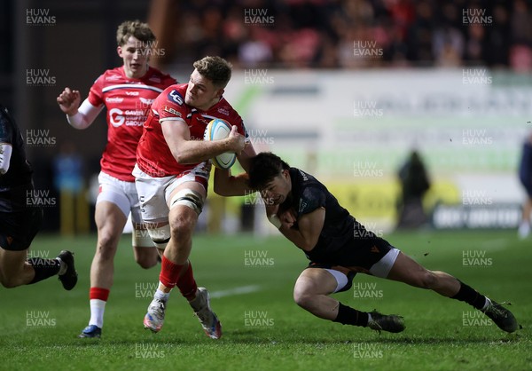 261225 - Scarlets v Ospreys - United Rugby Championship - Taine Plumtree of Scarlets is tackled by Dan Edwards of Ospreys 