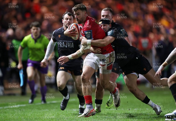261225 - Scarlets v Ospreys - United Rugby Championship - Johnny Williams of Scarlets is tackled by Owen Watkin of Ospreys 