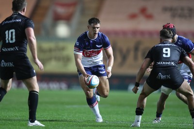 180926 - Scarlets v Saracens - Preseason Friendly - Joe Hawkins of Scarlets kicks past Owen Farrell of Saracens 