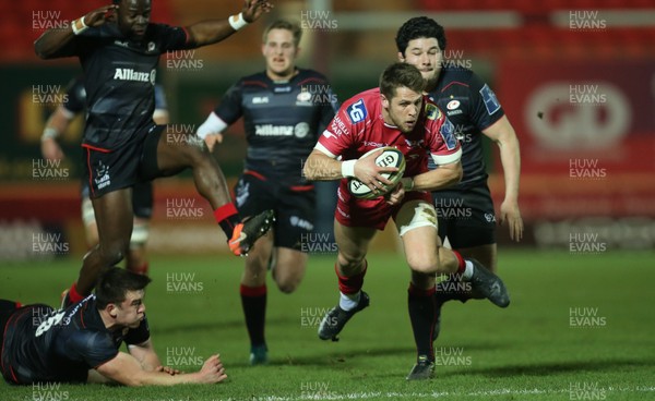 270117 - Scarlets v Saracens, Anglo Welsh Cup - Tom Williams of Scarlets is ankle tap tackled by Matt Gallagher of Saracens