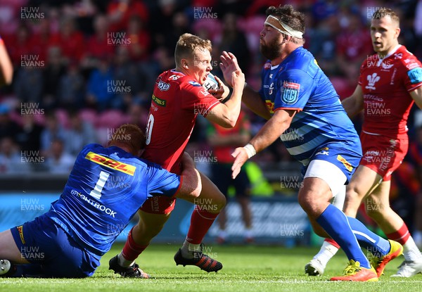 210522 - Scarlets v Stormers - United Rugby Championship - Sam Costelow of Scarlets is tackled by Frans Malherbe and Steven Kitshoff of Stormers