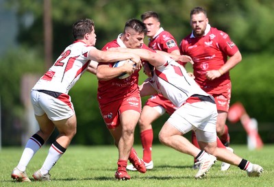 240819 - Scarlets A v Ulster A - Celtic Cup - Dominic Booth of Scarlets A is tackled by Ben Power and Zack McCall