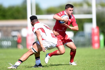 240819 - Scarlets A v Ulster A - Celtic Cup - Ioan Hughes of Scarlets A is tackled by JJ McKee