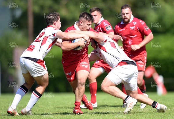 240819 - Scarlets A v Ulster A - Celtic Cup - Dominic Booth of Scarlets A is tackled by Ben Power and Zack McCall