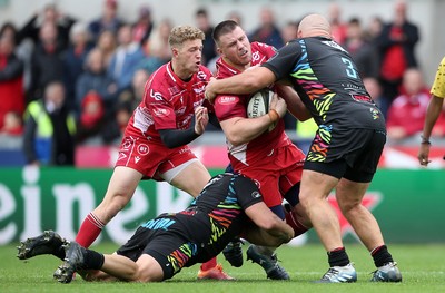 121019 - Scarlets v Zebre Rugby - Guinness PRO14 - Rob Evans of Scarlets is tackled by Mick Kearney and Alexandru Tarus of Zebre