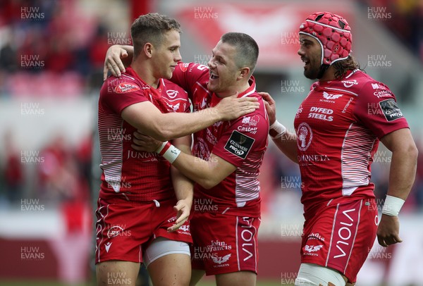 121019 - Scarlets v Zebre Rugby - Guinness PRO14 - Kieran Hardy of Scarlets celebrates scoring a try with Steff Evans and Josh Macleod