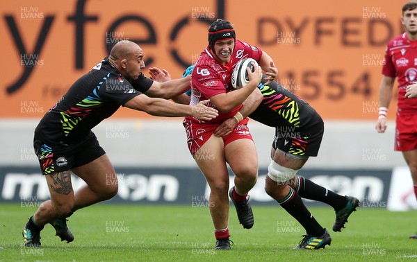 121019 - Scarlets v Zebre Rugby - Guinness PRO14 - Taylor Davies of Scarlets is tackled by Daniele Rimpelli and Mick Kearney of Zebre