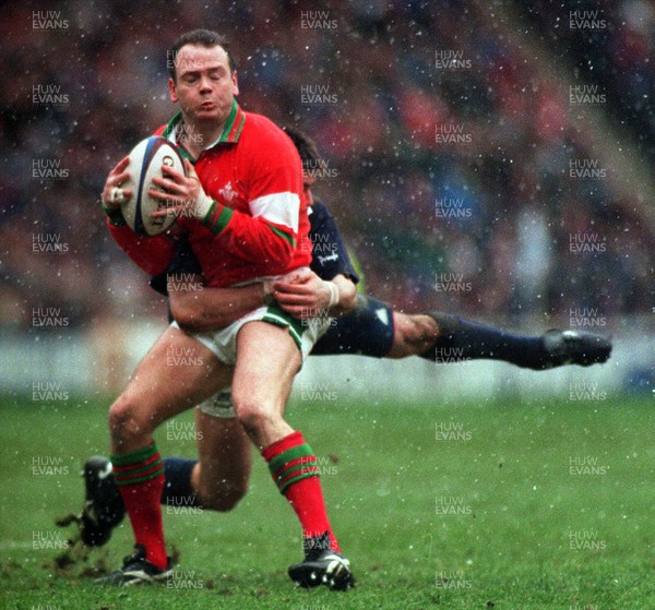 040395 - Scotland v Wales - Five Nations - Ieuan Evans of Wales is tackled by Kenny Logan of Scotland