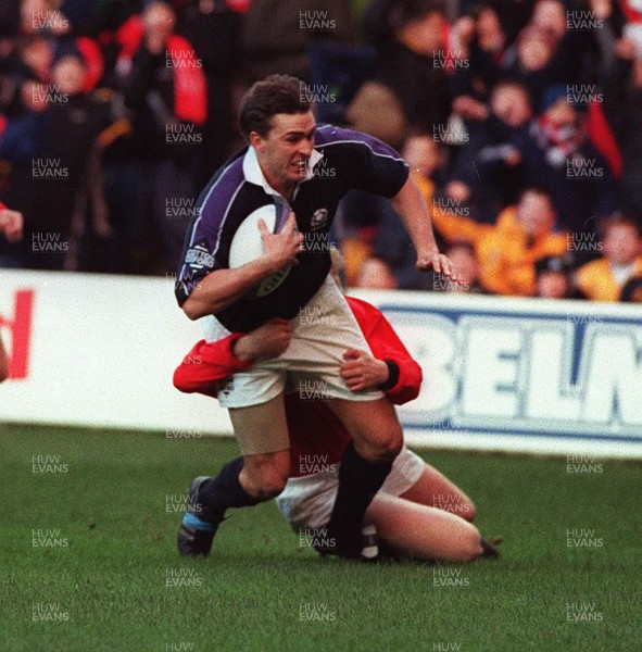 060299 - Scotland v Wales - Five Nations - John Leslie of Scotland dives in to score a try despite the tackle of Neil Jenkins