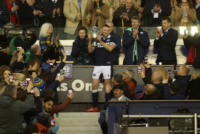 080325 - Scotland v Wales - Guinness 6 Nations Championship - Gareth Anscombe of Wales lifts the Doddie Weir Cup