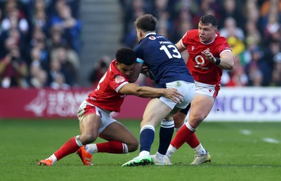 080325 - Scotland v Wales - Guinness 6 Nations Championship - Huw Jones of Scotland is tackled by Ben Thomas and Elliot Dee of Wales 