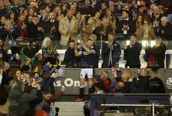 080325 - Scotland v Wales - Guinness 6 Nations Championship - Gareth Anscombe of Wales lifts the Doddie Weir Cup