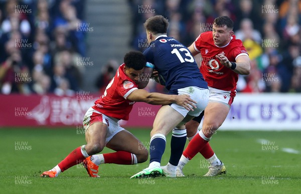 080325 - Scotland v Wales - Guinness 6 Nations Championship - Huw Jones of Scotland is tackled by Ben Thomas and Elliot Dee of Wales 