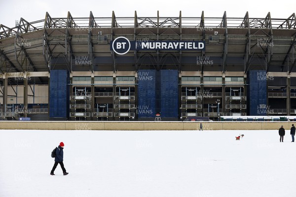 130221 - Scotland v Wales - Guinness 6 Nations - People walk past Murraryfield Stadium in the snowy conditions