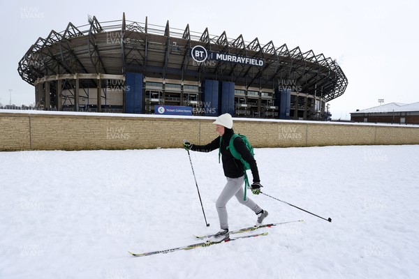 130221 - Scotland v Wales - Guinness 6 Nations - A women skis past Murrayfield Stadium in the snow