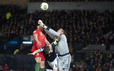 220313 -  Scotland v Wales - 2014 FIFA World Cup Qualifier -  Hampden Park - Scotland - Allan McGregor of Scotland beats Hal Robson-Kanu of Wales to the ball as Gary Caldwell of Scotland gets crushed between the two players 