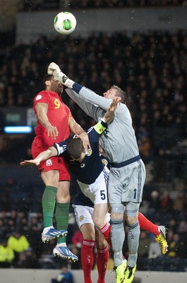 220313 -  Scotland v Wales - 2014 FIFA World Cup Qualifier -  Hampden Park - Scotland - Allan McGregor of Scotland beats Hal Robson-Kanu of Wales to the ball as Gary Caldwell of Scotland gets crushed between the two players 