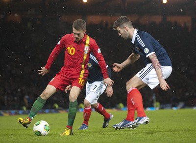 220313 -  Scotland v Wales - 2014 FIFA World Cup Qualifier -  Hampden Park - Scotland - Aaron Ramsey of Wales, left, is tracked by Charlie Mulgrew of Scotland 