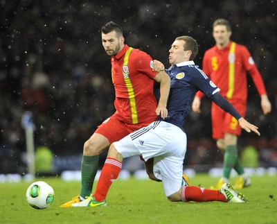 220313 -  Scotland v Wales - 2014 FIFA World Cup Qualifier -  Hampden Park - Scotland - Joe Ledley of Wales is tackled by James McArthur of Scotland 