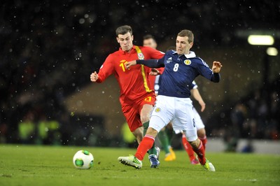 220313 -  Scotland v Wales - 2014 FIFA World Cup Qualifier -  Hampden Park - Scotland - James McArthur of Scotland, right, clears under pressure from Gareth Bale of Wales 