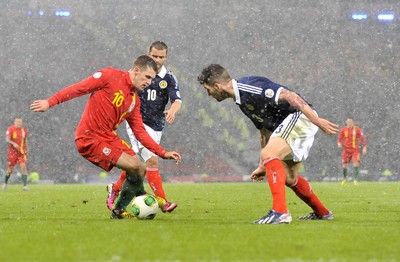 220313 -  Scotland v Wales - 2014 FIFA World Cup Qualifier -  Hampden Park - Scotland - Aaron Ramsey of Wales, left, takes on Charlie Mulgrew of Scotland