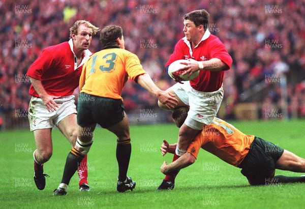 01.12.96...Wales v Australia  Wales' Scott Gibbs is tackled by Tim Horan as Gareth Thomas supports 