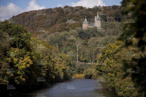 141020 - Seasonal Weather - Picture shows a man fishing on the River Taff at Taffs Well, in the shadow of Castell Coch as the autumn colours start to shine through
