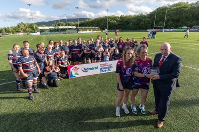 310526 - Senghenydd Sirens Admiral Womens Championship Presentation - Roy Wilkinson, WRU National Council Member presents Senghenydd Sirens co-captains, Holly Dempsey and Raf Taylor with the trophy after Sirens win the Admiral Women's National League Championship 