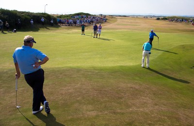 250714 -  The Senior Open Championship, Royal Porthcawl Golf Club, Wales - Colin Montgomerie of Scotland looks on as Tom Watson of the USA looks to putt on the 13th