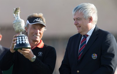 270714 -  The Senior Open Championship, Royal Porthcawl Golf Club, Wales - Germany's Bernhard Langer celebrates with the trophy after winning the Senior Open at Royal Porthcawl Golf Club by 13 shots, alongside the First Minister of Wales Carwyn Jones