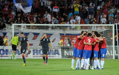 110912 - Serbia v Wales - 2014 World Cup Qualifier -Chris Gunter and Darcy Blake of Wales look dejected as Serbia players celebrate