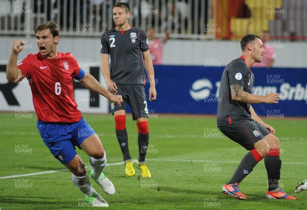 110912 - Serbia v Wales - 2014 World Cup Qualifier -Branislav IVANOVIC of Serbia celebrates a goal as Chris Gunter and Darcy Blake of Wales look dejected