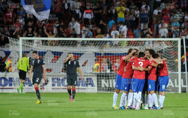 110912 - Serbia v Wales - 2014 World Cup Qualifier -Chris Gunter and Darcy Blake of Wales look dejected as Serbia players celebrate
