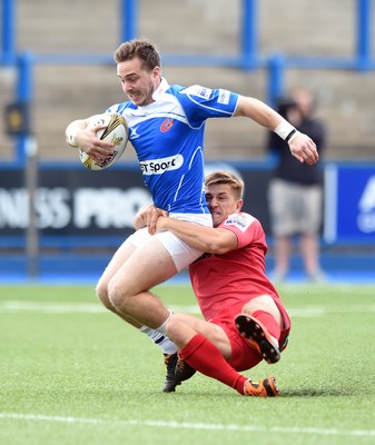 150815 - Singha Premiership Rugby 7s Dragons Jonathan Lewis  is tackled by Scarlets Lee Rees