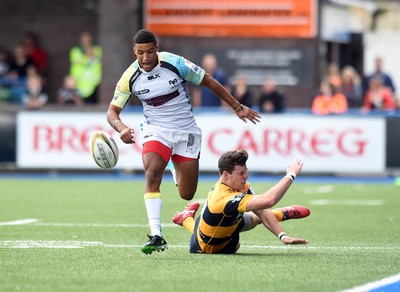 150815 - Singha Premiership Rugby 7s Ospreys Keelan Giles puts in a kick as Blues Owen Jenkins tackles