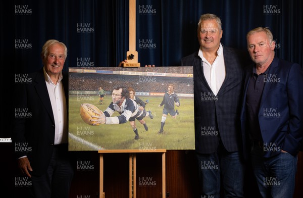 060722 - The Greatest Try Anniversary with Sir Gareth Edwards - Sir Gareth Edwards with Scott Salter and Adrian Davies with the specially commissioned painting of his 1973 Barbarian try against New Zealand to mark his 75th birthday, 50th wedding anniversary and 50 years since scoring “The Greatest Try” 