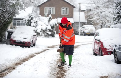 180113 - Cardiff- Snow -   Postman Craig Canning helps residents in Cardiff grit the roads 