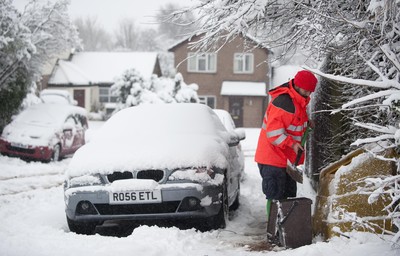 180113 - Cardiff- Snow -   Postman Craig Canning helps residents in Cardiff grit the roads 