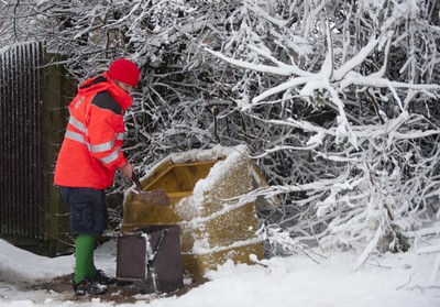 180113 - Cardiff- Snow -   Postman Craig Canning helps residents in Cardiff grit the roads 