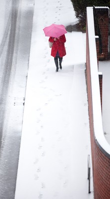 180113 - Snow hits south Wales -A worker makes her way through the snow in Cardiff