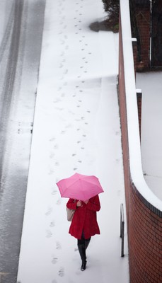 180113 - Snow hits south Wales -A worker makes her way through the snow in Cardiff